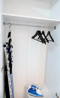 a closet with two black hangers on a wall at Rose City Centre Apartment in Belgrade