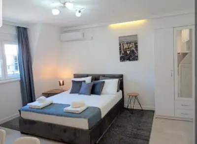 a bedroom with a large bed with blue pillows at Rose City Centre Apartment in Belgrade