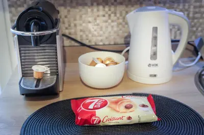 a bag of food sitting on a plate next to a coffee maker at Central Nusic apartment in Belgrade