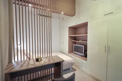 a room with a desk and a bed and a tv at Central Nusic apartment in Belgrade