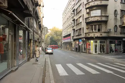 a city street with a car driving down the street at Central Nusic apartment in Belgrade