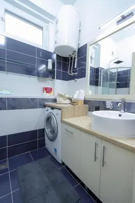 a bathroom with a sink and a washing machine at Central Nusic apartment in Belgrade