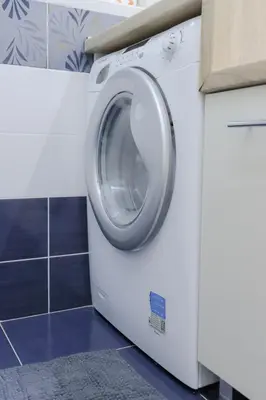 a white washing machine in a kitchen with a tile floor at Central Nusic apartment in Belgrade
