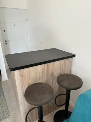 a counter with two tables and two stools at lovely studio apartment in Belgrade