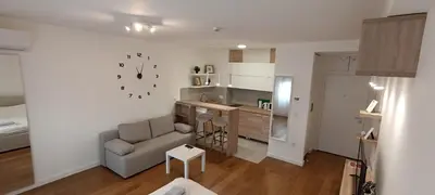 a living room with a couch and a kitchen at Stela apartment in Belgrade