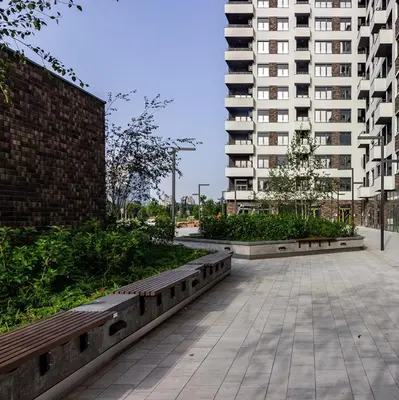 a park with two benches and a tall building at Stela apartment in Belgrade