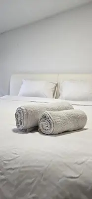 two rolled towels sitting on a bed at TeaBG in Belgrade