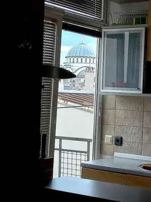 a kitchen window with a view of a building at Prostrani dupleks u istorijskom centru grada Anna in Belgrade