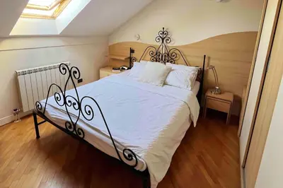a bedroom with a large white bed with a wooden floor at Prostrani dupleks u istorijskom centru grada Anna in Belgrade