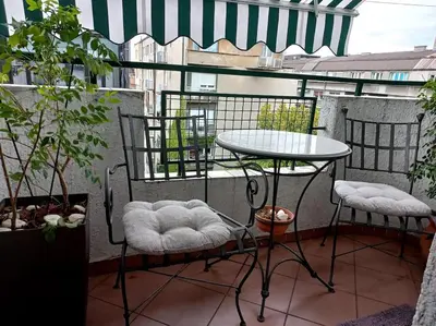 a balcony with a table and two chairs and a table at Prostrani dupleks u istorijskom centru grada Anna in Belgrade