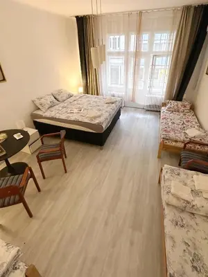 a room with a bed and a table and chairs at The Horse Monument Hostel in Belgrade