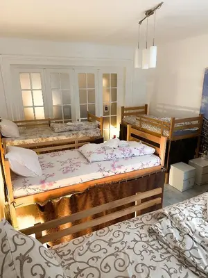 a bedroom with three beds in a room at The Horse Monument Hostel in Belgrade