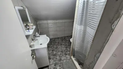 a small bathroom with a shower and a sink at Sobe i apartmani Djordjevic in Mladenovac