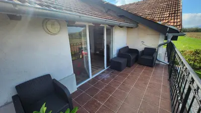a balcony with two black chairs on a house at Sobe i apartmani Djordjevic in Mladenovac