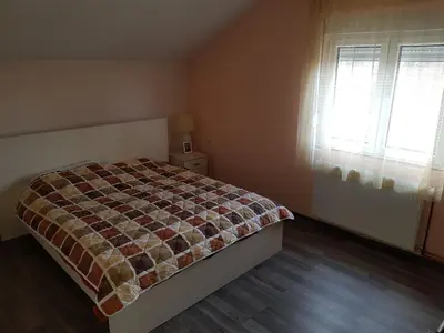 a bedroom with a bed and two windows in it at Sobe i apartmani Djordjevic in Mladenovac