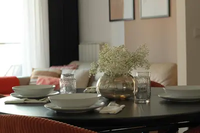 a table with plates and bowls and a vase of flowers at Belgrade Boutique Verde in Belgrade