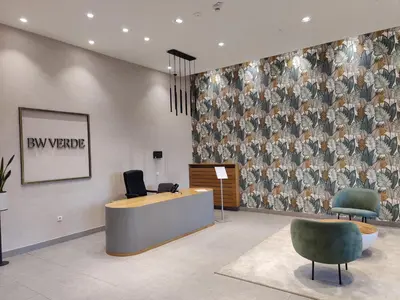 a lobby with a reception desk and two chairs at Belgrade Boutique Verde in Belgrade