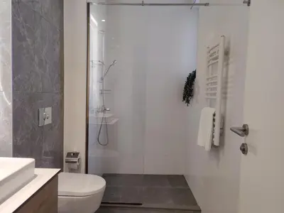 a white bathroom with a shower and a toilet at Belgrade Boutique Verde in Belgrade