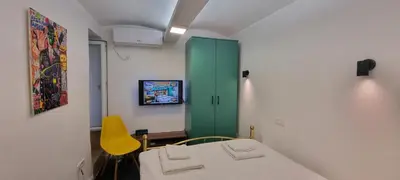 a room with a green cabinet and a yellow chair at Mi Casita Studio in Belgrade