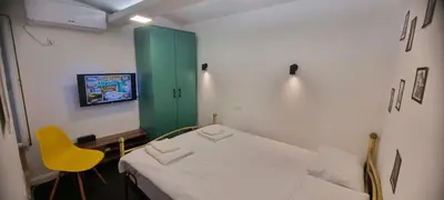 a hospital room with a bed and a yellow chair at Mi Casita Studio in Belgrade