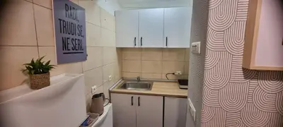 a small kitchen with white cabinets and a sink at Mi Casita Studio in Belgrade