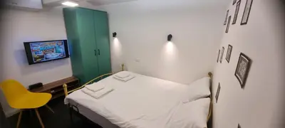 a hospital room with a bed and a yellow chair at Mi Casita Studio in Belgrade