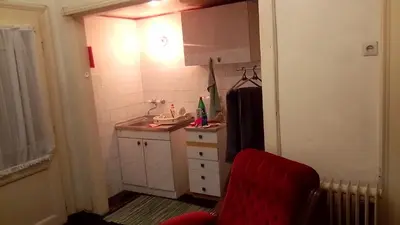 a small kitchen with a sink and a red chair at Teranuovo in Belgrade