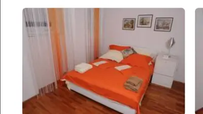 a bed with an orange comforter in a room at Central market plaza Promo price ! in Belgrade