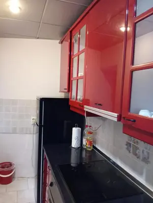 a kitchen with red cabinets and a black counter top at Central market plaza Promo price ! in Belgrade