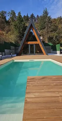 a swimming pool with a pyramid shaped house at Villa SS Black Fruška Gora in Čortanovci