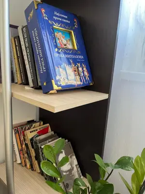 a book shelf filled with books next to a plant at La Casa Stan na dan in Belgrade