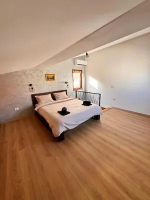 a large bed in a room with a wooden floor at Johnny Apartment in Belgrade