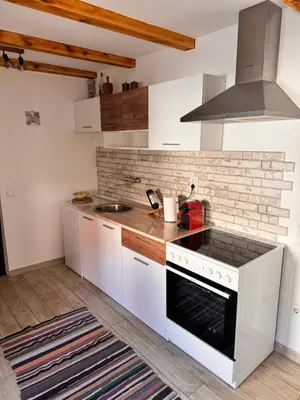a kitchen with white cabinets and a stove top oven at Johnny Apartment in Belgrade
