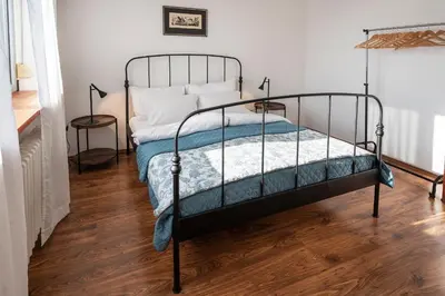 a bed with a metal frame in a room at Čubrina - central 2bdrm & 45m2 Rooftop Terrace in Belgrade