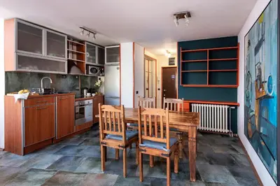 a kitchen with a wooden table and chairs at Čubrina - central 2bdrm & 45m2 Rooftop Terrace in Belgrade
