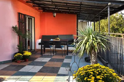 a patio with a table and chairs on a house at Čubrina - central 2bdrm & 45m2 Rooftop Terrace in Belgrade
