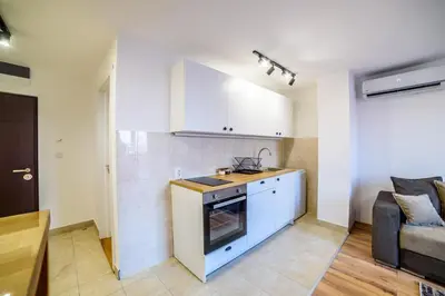 a kitchen with a stove top oven next to a couch at Apartmani Sloboda in Belgrade