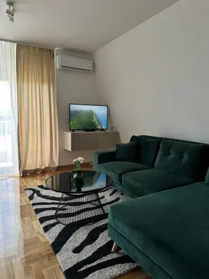 a living room with a green couch and a table at Dorcol Dream Apartment City View Terrace in Belgrade