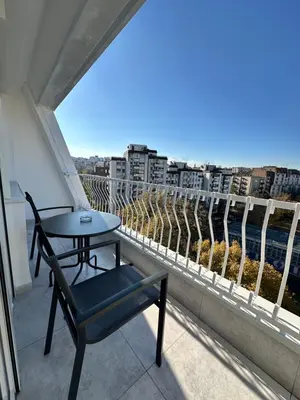 a table and a chair on a balcony with a view at Dorcol Dream Apartment City View Terrace in Belgrade