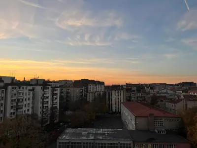 a view of a city at sunset with buildings at Dorcol Dream Apartment City View Terrace in Belgrade