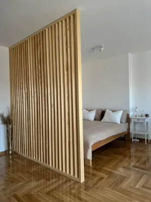 a room with a bed with a wooden partition at Dorcol Dream Apartment City View Terrace in Belgrade