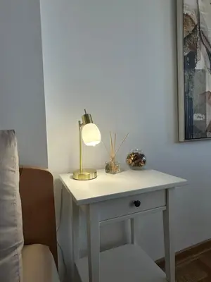 a white table with a lamp on it next to a chair at Dorcol Dream Apartment City View Terrace in Belgrade