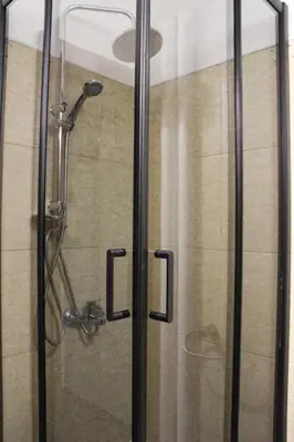 a shower with a glass door with the letter l at Gavrila Principa Apartment in Belgrade