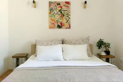 a bed with white pillows and a painting above it at Central apt Jovanova in Belgrade