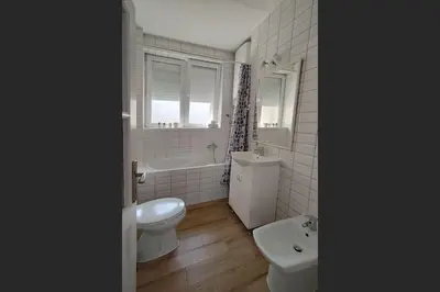 a white bathroom with a toilet and a sink at Central apt Jovanova in Belgrade