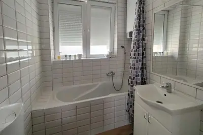a white bathroom with a tub and a sink at Central apt Jovanova in Belgrade