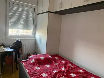 a bedroom with a bed with a red comforter at Boba in Belgrade