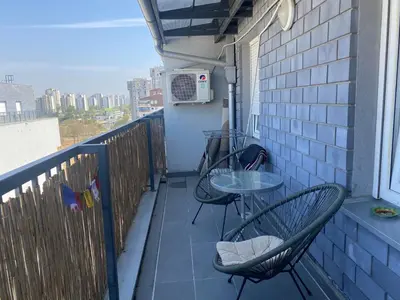 a balcony with two chairs and a table and a microwave at Boba in Belgrade