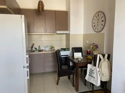 a kitchen with a table and a clock on the wall at Boba in Belgrade