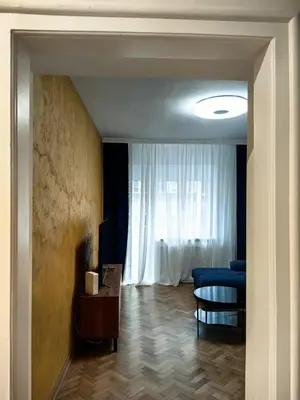 a living room with a blue couch and a window at Apartman Cetkovic in Belgrade